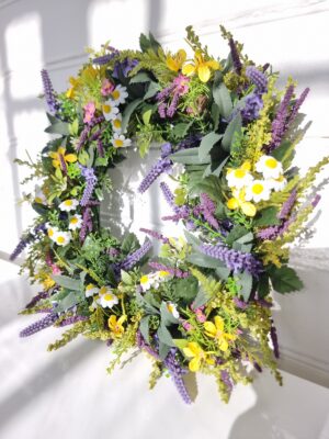 Konstgjord krans med blommor. Besök blickfång.se