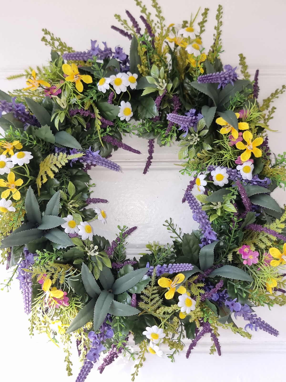 Konstgjord krans med blommor. Besök blickfång.se