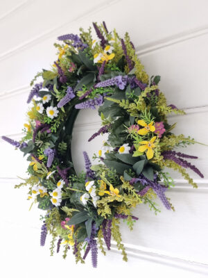 Konstgjord krans med blommor. Besök blickfång.se