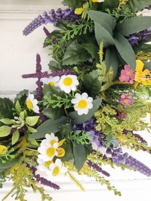 Konstgjord krans med blommor. Besök blickfång.se