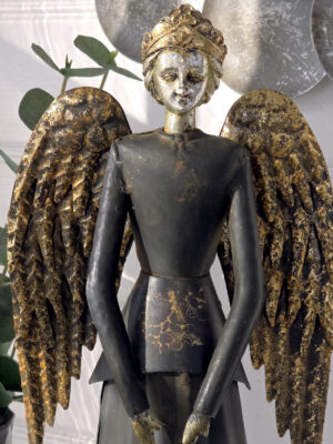 närbild på svart ängel i metall med vingar i guld