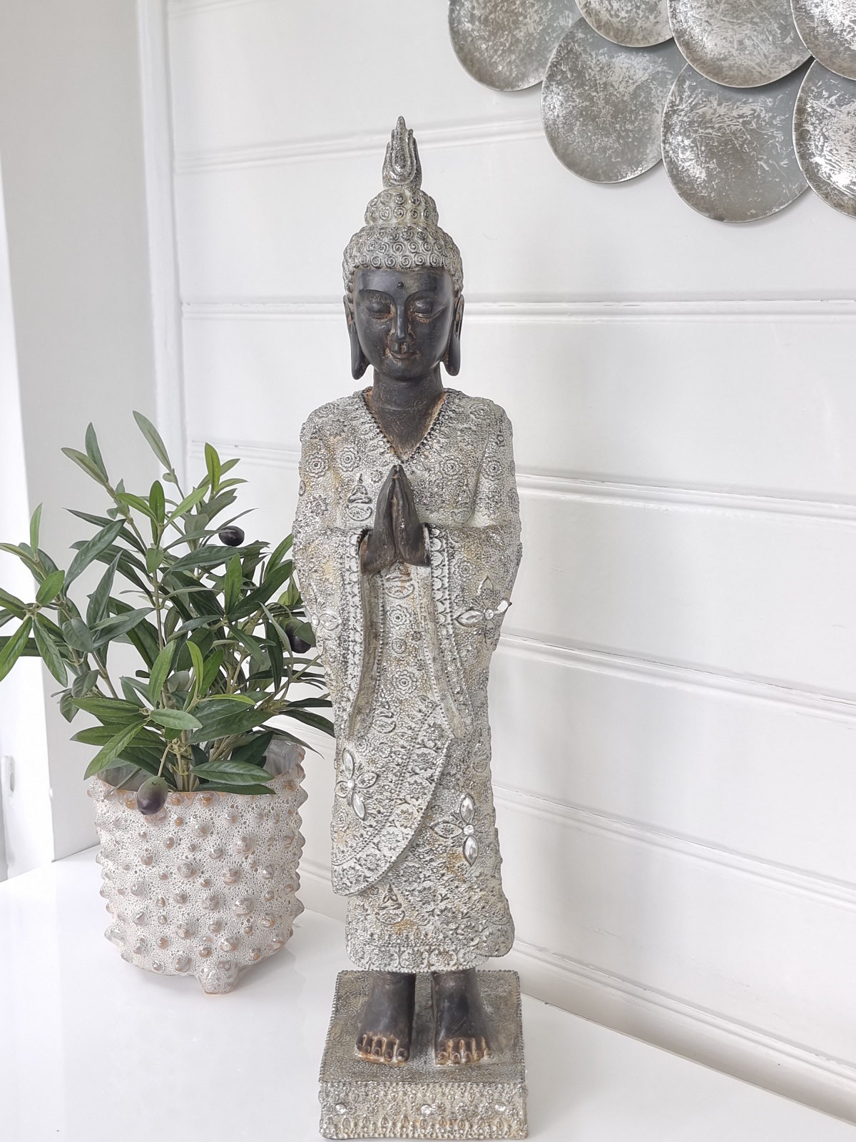 Stående brun buddha med detaljer i silver för dekoration