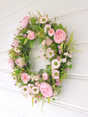 Konstgjord krans med bellis och ranuncel. Besök blickfång.se