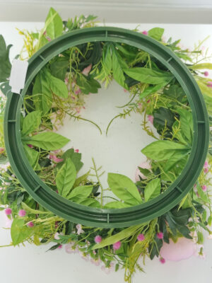 Konstgjord krans med bellis och ranuncel. Besök blickfång.se