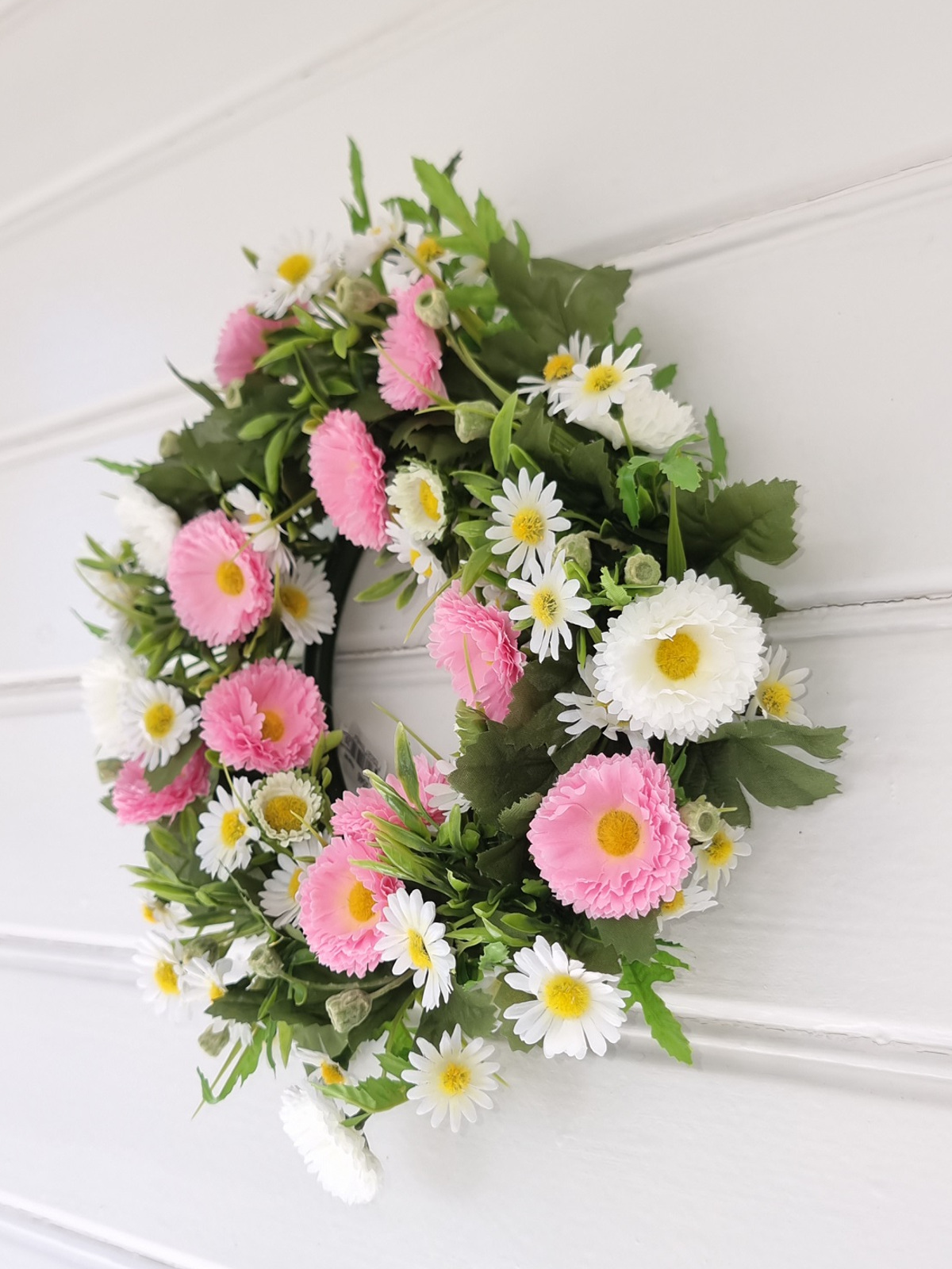 Konstgjord krans med vita och rosa blommor. Besök Blickfång.se