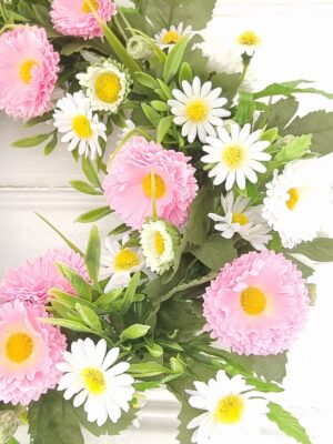 Konstgjord krans med vita och rosa blommor. Besök blickfång.se