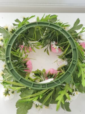 Konstgjord krans med vita och rosa blommor. Besök blickfång.se
