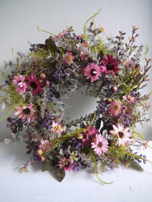 Naturtrogen konstgjord dörrkrans med blommor. Besök Blickfång.se