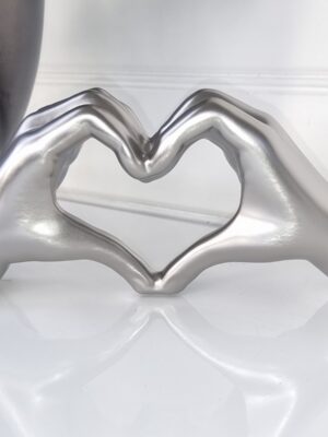 Händer i silver formade som hjärta. Besök Blickfång.se