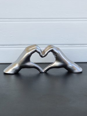 Händer i silver formade som hjärta. Besök blickfång.se