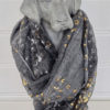 Grå scarf med mönster i guld och silver. Besök Blickfång.se