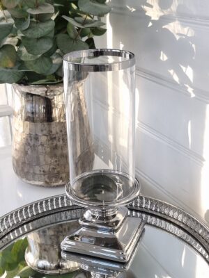 Ljuslykta med glascylinder på fot i silver. Besök blickfång.se