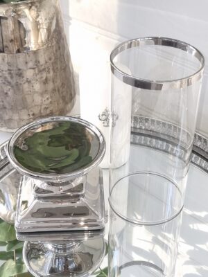 Ljuslykta med glascylinder på fot i silver. Besök blickfång.se