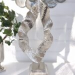 Flame skulptur i silver på fot. Besök Blickfång.se