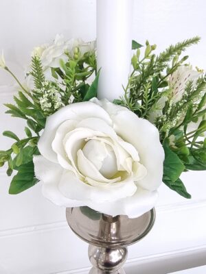 Fyllig ljusmanschett med olika vita blommor. Besök Blickfång.se