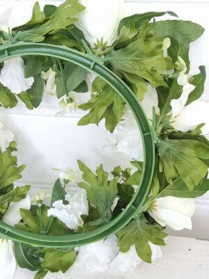 Konstgjord dörrkrans med vita blommor. Besök Blickfang.se