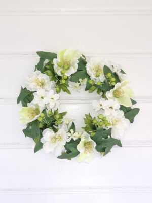 Konstgjord dörrkrans med vita blommor. Besök Blickfang.se