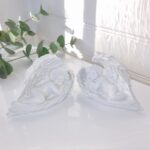 Vit ängel liggande i vinge. Besök Blickfång.se