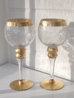Ett par ljuslyktor i glas på fot med guld. Besök Blickfång.se