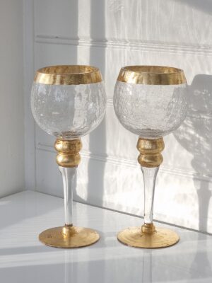 Ett par ljuslyktor i glas på fot med guld. Besök Blickfång.se