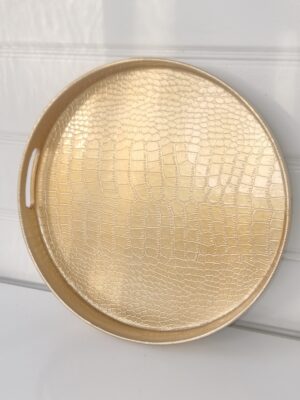 Rund bricka i guld med orm mönster. Besök Blickfång.se
