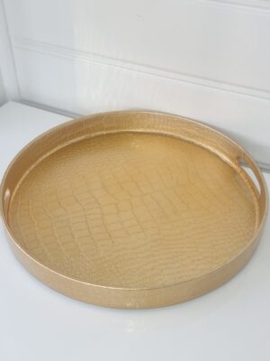 Rund bricka i guld med orm mönster. Besök Blickfång.se