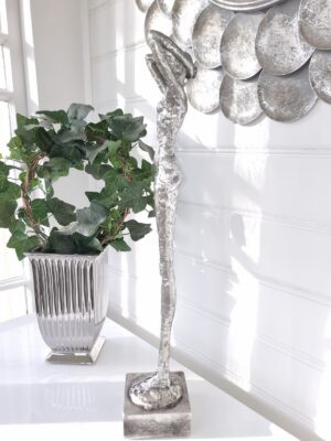 Hög smal dam figur i silver. Besök Blickfång.se
