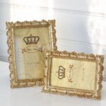 Fotoram i guld med dekoration runt kanten. Besök blickfång.se