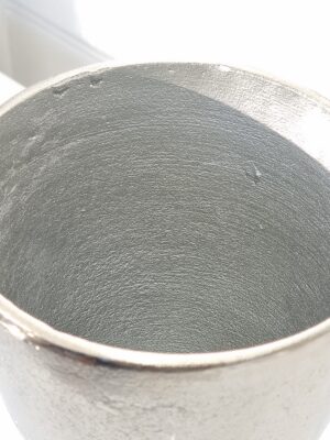 Rund kruka på fot i silver metall. Besök blickfång.se