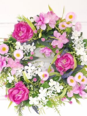 Konstgjord krans med camelia blommor i rosa. Besök blickfång.se