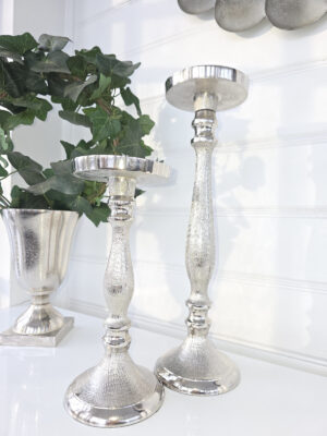 En stor och en liten blockljusstake i silver metall