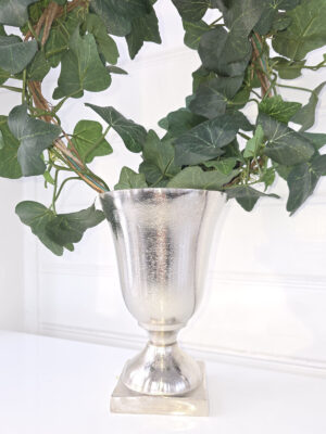 närbild på en rund kruka på fot i ruff metall