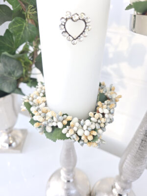 Närbild på en ljusmanschett till blockljus med vita pärlor och bär